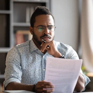 A man sitting at a table with papers in front of him.